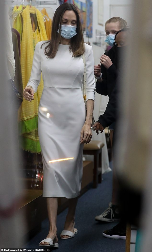 Family in tow: The actress was dressed in a tailored white midi dress and matching Fendi slide sandals as she headed into the shop