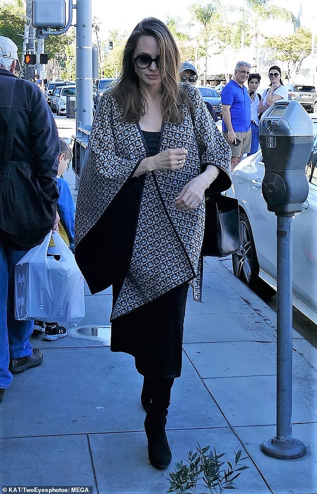 Fashion: The 43-year-old actress donned a Salvatore Ferragamo reversible cape with a black skirt amid reports that Pitt has been dating Charlize Theron for one month, according to The Sun