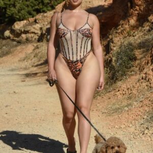 Demi Rose enjoying a scenic walk with her furry friend by the beautiful shores of Ibiza. Embracing those beachy vibes and flawless style.