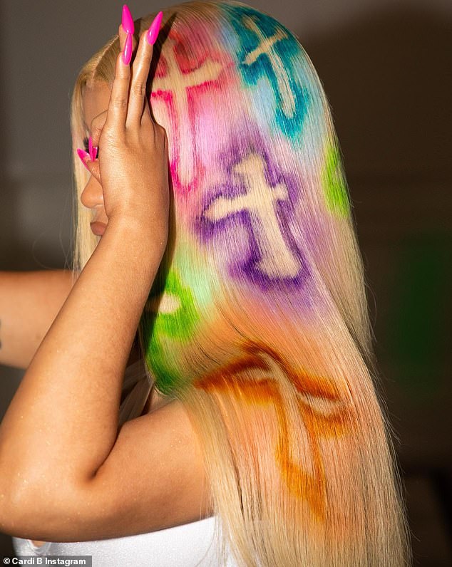 Eyes up: The point of the Cardi's new pictures, however, was to show off her sleek platinum hairdo sprayed with colorful crosses