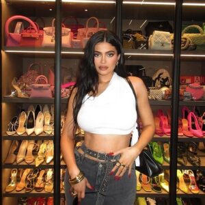 Kylie Jenner shows off her taut tummy in a white crop top while displaying her vast shoe and purse collection