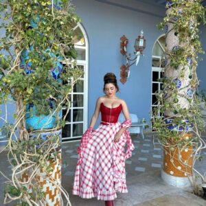 Demi Rose stuns in a fiery red corset and chic checked princess dress, leaving fans breathless with her captivating style and beauty.