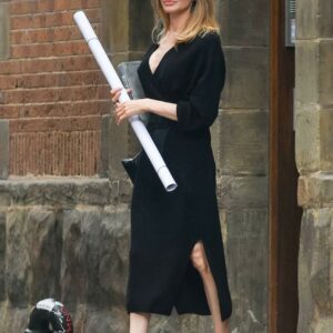 Iconic elegance Angelina Jolie radiates sophistication in a chic black dress, capturing the essence of timeless style on the vibrant streets of NYC.