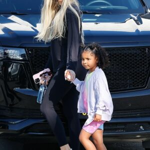 Khloe Kardashian exudes chic vibes in her sleek leggings while enjoying a precious moment with daughter True under the sunny LA skies.