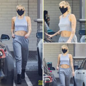 Miley Cyrus goes braless in a racerback tank top as she loads up on essentials